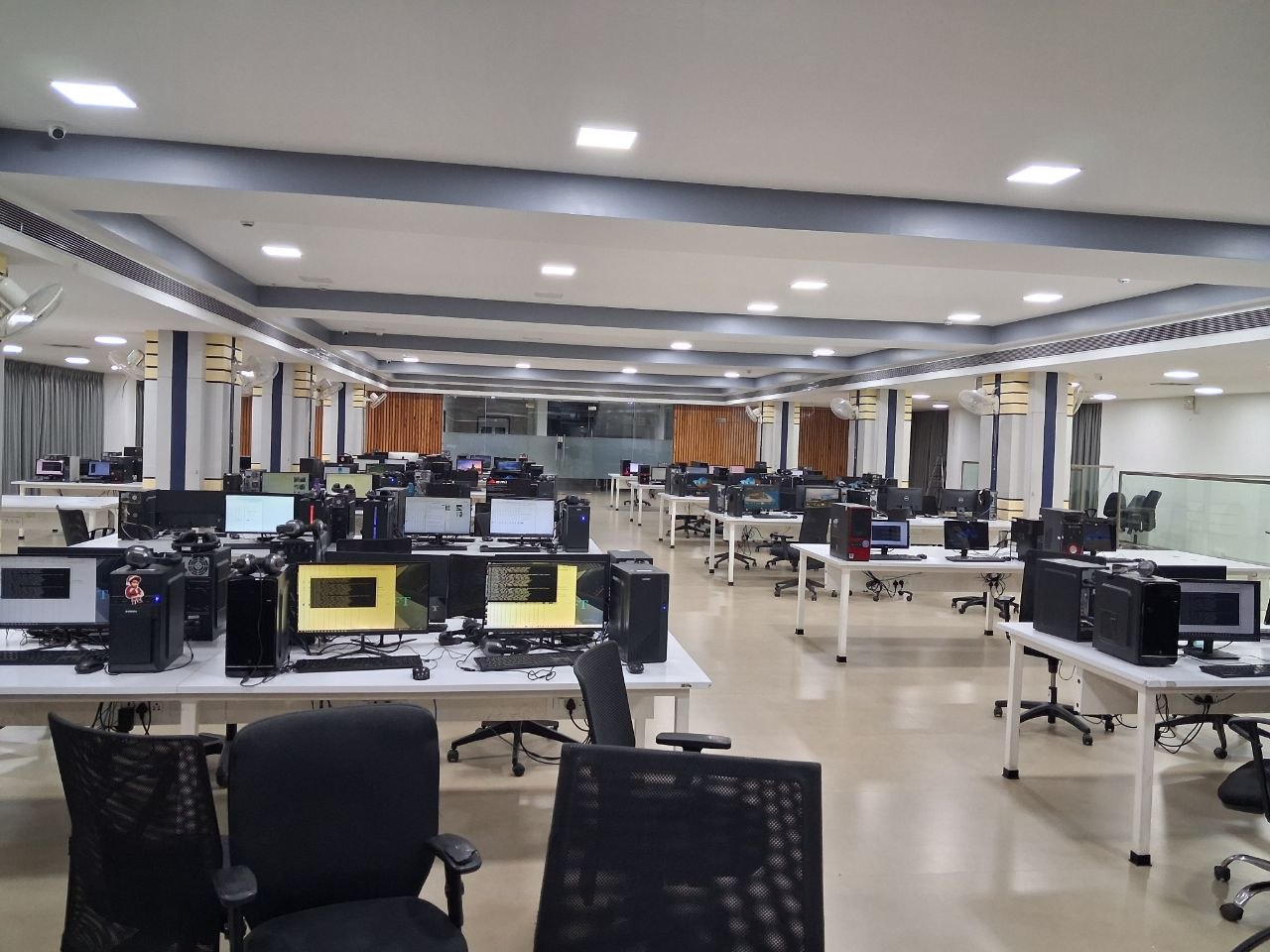 An office aisle lined with desktop towers and routers.